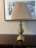 Full view of brass table lamp with shade