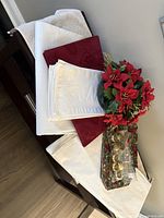 All items grouped on furniture: tablecloth, napkins, red textiles, green textiles, napkin rings, centerpiece