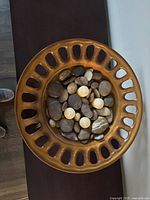 Top view showing copper/bronze glass bowl filled with river stones and marbles
