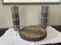 Stacked leopard print plates flanked by stacked tumblers