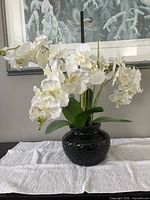 Full view of silk orchid arrangement showing flowers, leaves, and vase