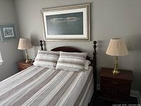 Both brass table lamps on bedside tables with shades attached