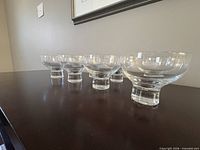 Side view of five bowls showing cylindrical foot and clear glass clarity