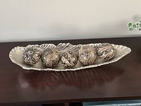 Silver metal tray holding five patterned resin spheres