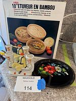 Boxed bamboo steamer, metal tray and porcelain candle holder visible