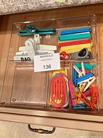 Drawer tray containing assorted plastic bag, chip and clothespin clips
