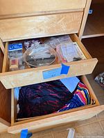 Open drawer with plastic bags containing hardware and fasteners