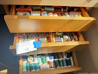 Open drawers showing thread spools and bobbins