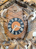 Front view of clock dial, carved leaf surround