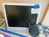 Front view of Sharp Aquos monitor, Salton mug warmer and cords