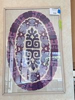 Full view of framed textile wall art under glass