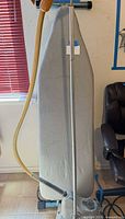 Ironing board front view with attached steamer pole and hose