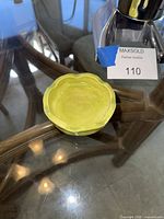 Green scalloped ceramic dish on glass table