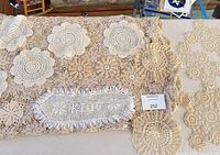 Lot overview showing tablecloth, oval doily, round doilies, filet piece