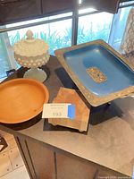 Group view of compote, wooden bowl, wood stand and blue metal tray