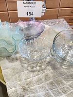 Group of assorted glass bowls and plate on towel