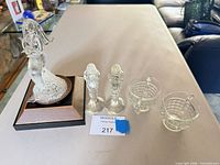 Group shot of all five clear glass items: mermaid figurine on wood base, pair of candlesticks, creamer, sugar bowl