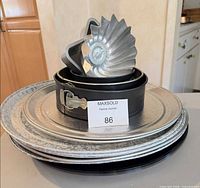 Stack of embossed trays with springform pan and fluted mold on top