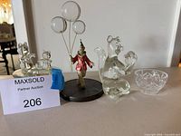 group view of music box with bear lid, clown with balloons, glass squirrel, crystal bowl