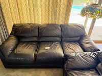 Front view of navy leather three-seat sofa showing cushions and overall condition