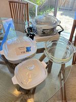 Group shot of CorningWare casseroles, Pyrex dishes, chafing stand set up on table