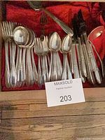 Drawer view of entire silver-plated flatware assortment on red lining