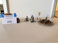 All items grouped: copper bowl, metal trinket box, three pewter figures, glass unicorn, brass shot set on tray