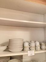 Stacks of bowls, mugs and accessory pieces on shelf