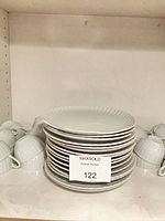 Stack of fluted-rim plates flanked by matching ribbed cups