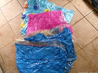 Four deflated vinyl inflatables laid out to show colors and styles