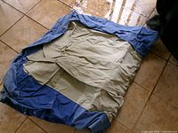Deflated blue and beige pool float on tile floor