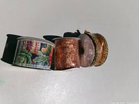 Three ribbon spools side by side showing patterns and colors