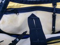 Interior of Tom Bihn bag showing yellow grid lining and black strap clips