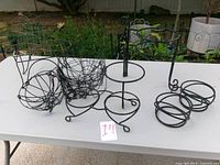 Group of metal plant stands and wire baskets on table