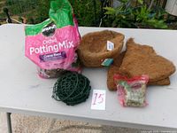 Full lot view showing potting mix bag, two coconut liners, plastic orchid basket, orchid food bag