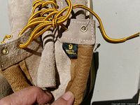 close-up of boot tongue showing suede texture, metal eyelets, yellow laces, size 9 tag, made in Vietnam