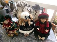 Group shot of three musical dolls and two plush owls
