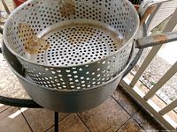 Pot with perforated strainer insert showing corrosion