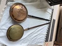 Two bed warmers laid side by side showing full length and pan surfaces