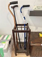 Full view of wooden stand holding three canes