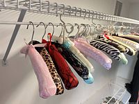 Row of assorted satin padded hangers on closet rod