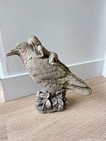 Front view of cast concrete raven with pixie sculpture