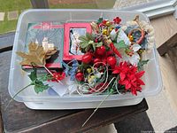 Overview of assorted ornaments and floral picks in storage bin