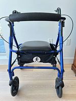 Front view of blue rollator walker showing wheels, seat, and storage pouch