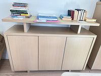 front view of light oak sideboard showing three doors and display shelf