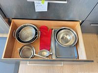 Drawer view showing all cookware, bakeware, strainer and oven mitt