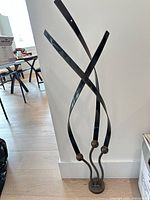 Front view of tall abstract metal sculpture against wall
