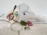 Group shot of all items: fan, necklaces, bracelets, scarf ring, pendant
