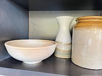 Bowl, vase, crock side by side on shelf