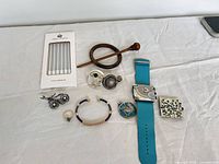 All items laid out including candles, jewellery, watch, scarf pins